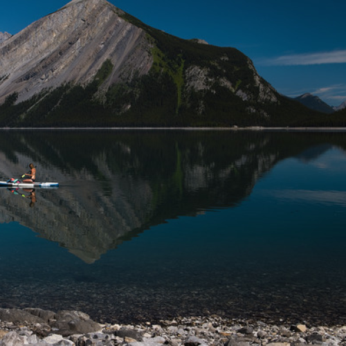 paddling along the shore of a still lake